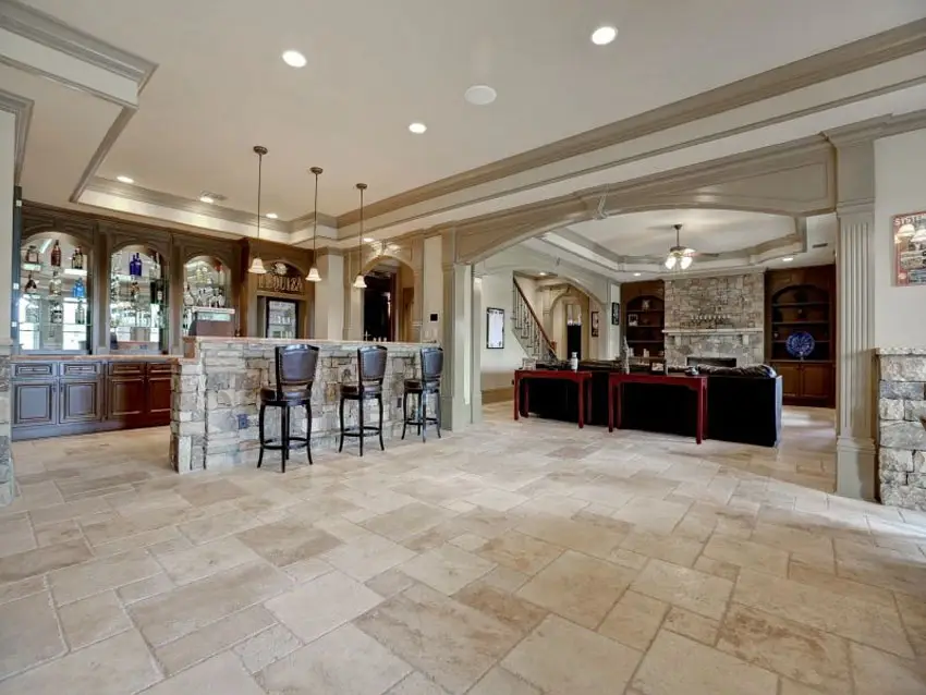 Basement bar with travertine floors and dark wood cabinetry