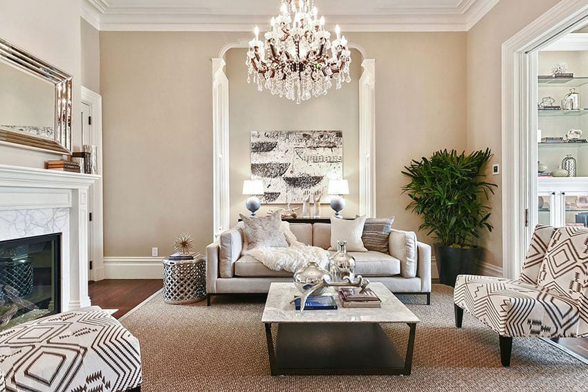 Chandelier, fireplace, textured sofa seats set in white room
