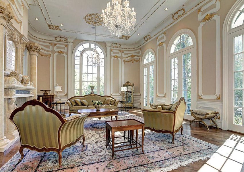 Living space with gold gilding and crown molding and wing back chairs