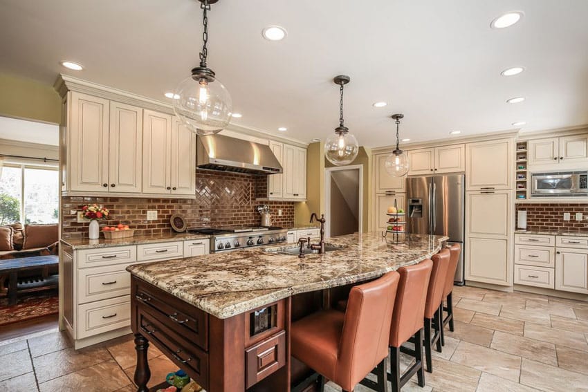 Traditional kitchen with white cabinets brick backsplash and dining island