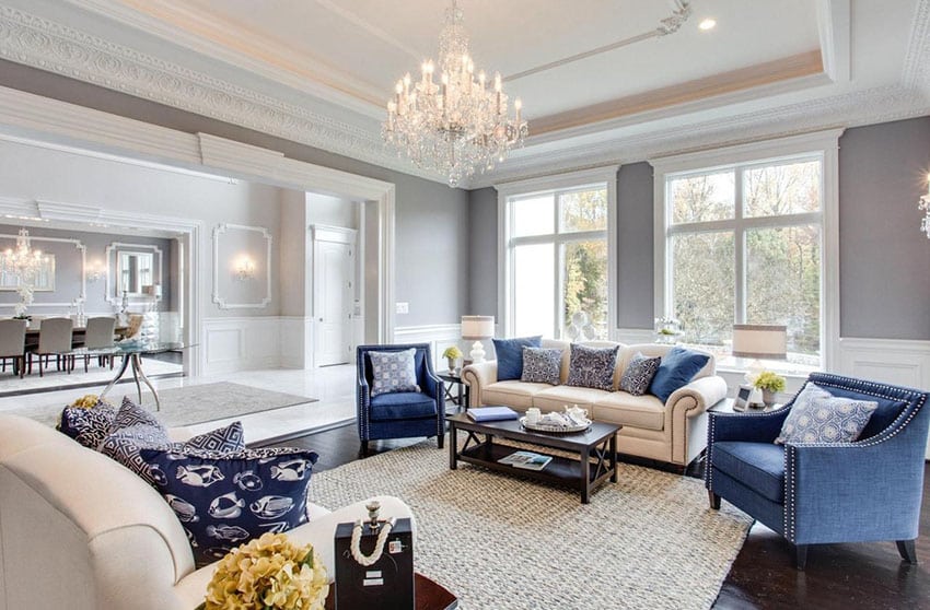 Room with tray ceiling and glass chandelier with blue color accents