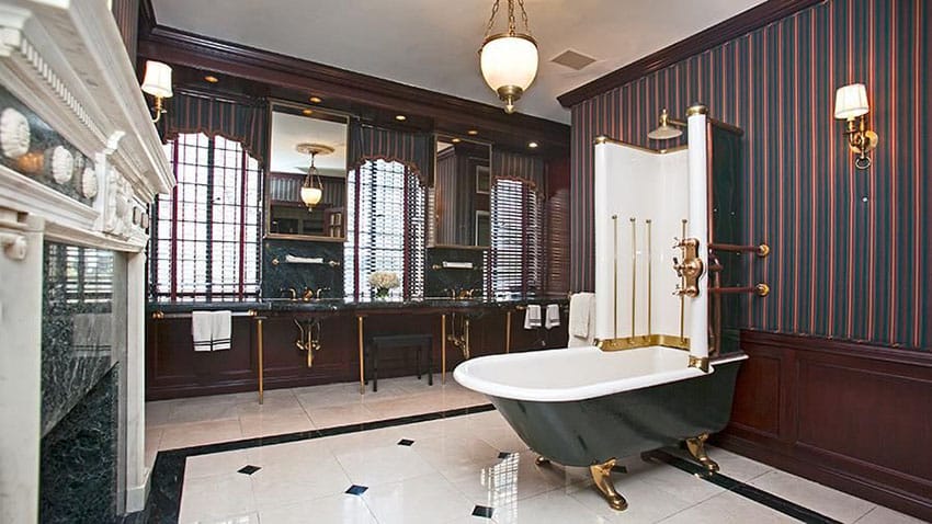 Bathroom with polished brass accents, vertical wallpaper and wall sconces