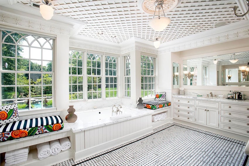 Traditional master bathroom with window seats and large soaking bathtub with garden views