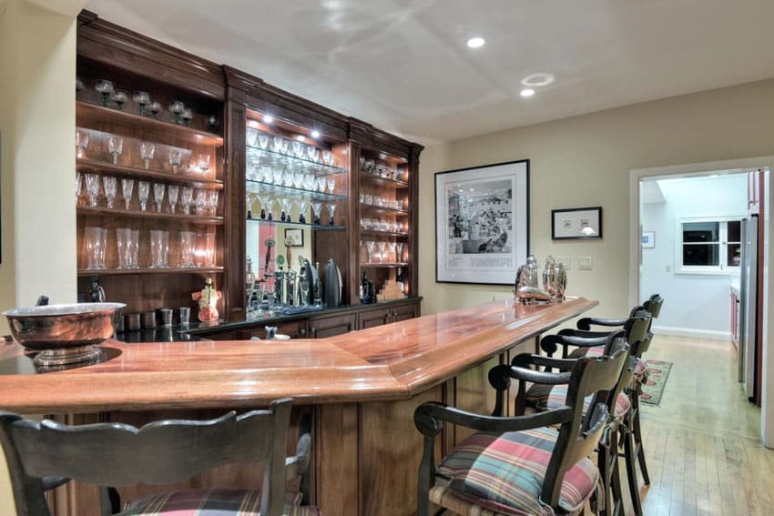 Room with polished wood counter, beige walls and glasses on shelves