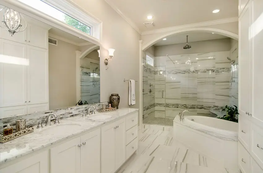 Transitional bathroom with drop-in bath tub, marble counters and crown molding