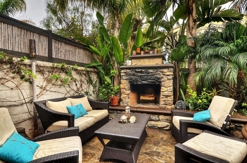 Tropical patio with fireplace palms and bamboo fence