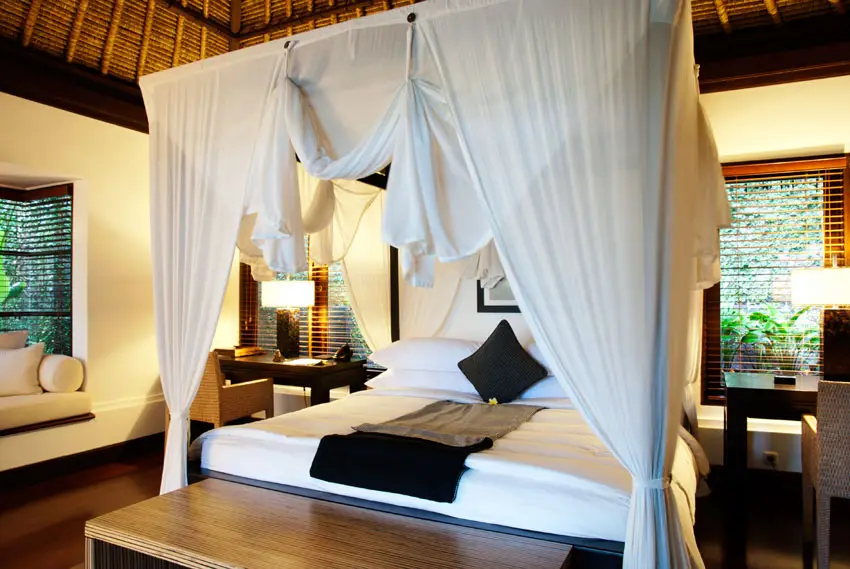 Tropical style bedroom with four post bed and curtains