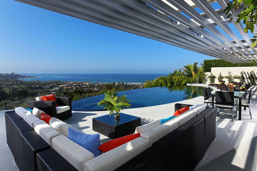 Upscale patio with ocean views facing infinity pool
