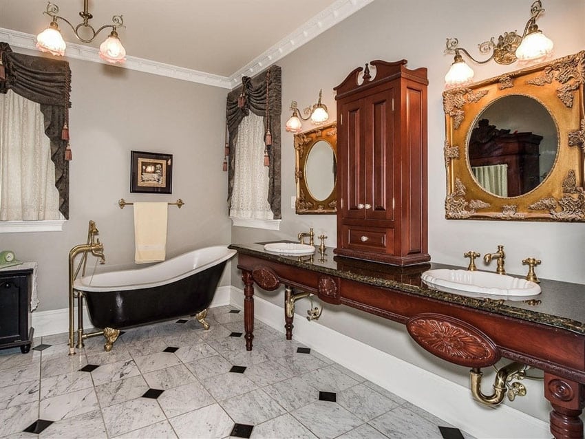 Bathroom with black tub with gold lion feet, table top cabinet and curtains