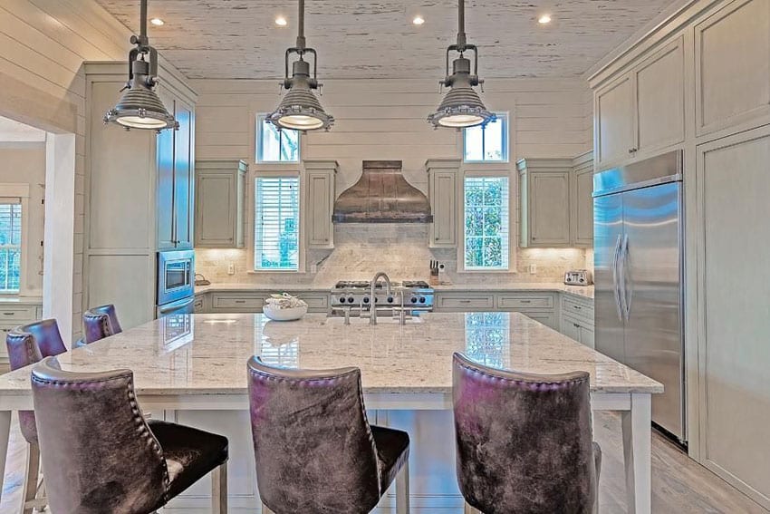 Kitchen with canopy type range hood, upholstered dining chairs and walls with moldings