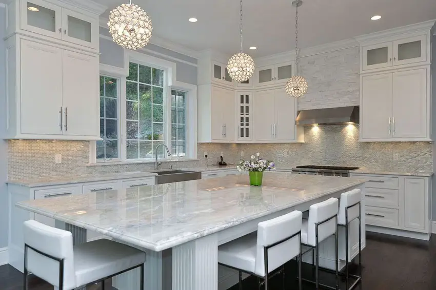 White cabinet kitchen with white wave granite countertops and breakfast bar