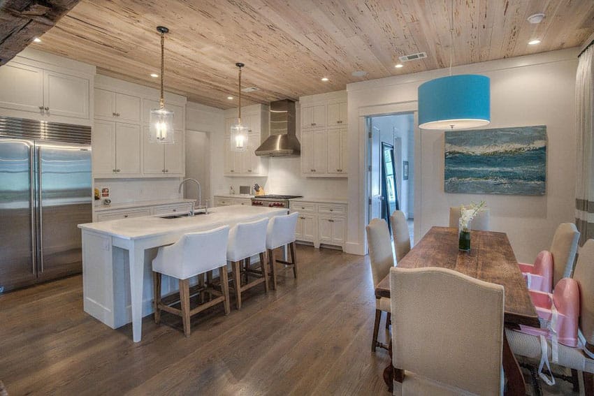 White cabinet kitchen with wood ceiling, flooring and dining island