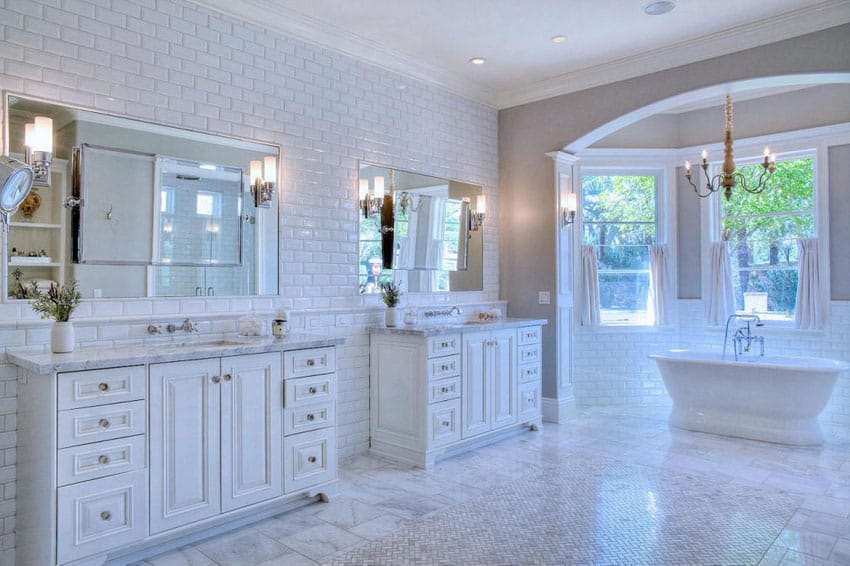 White master bathroom with subway tile and acrylic bathtub with window views