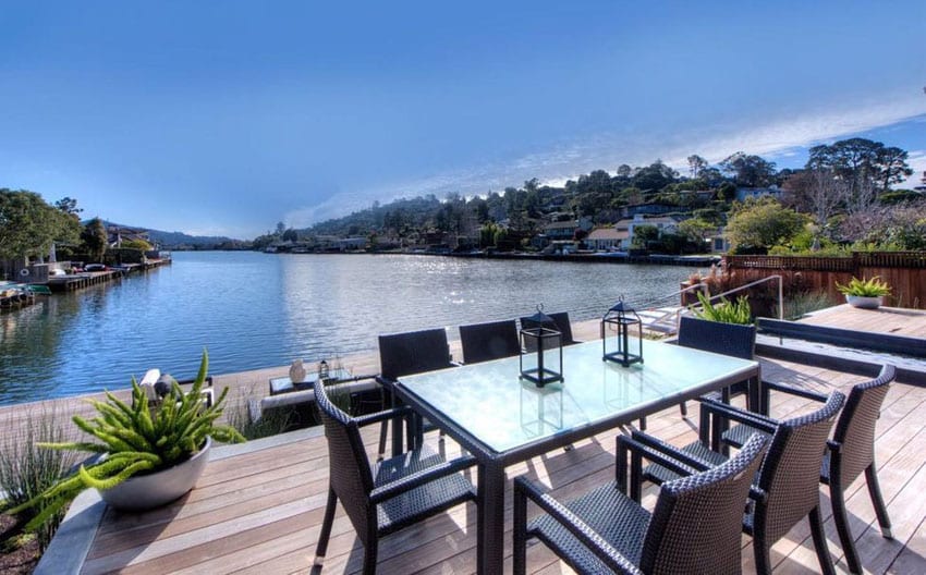 Wood deck with outdoor dining table overlooking canal