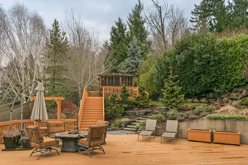 Wood deck with stairs leading up to small cottage