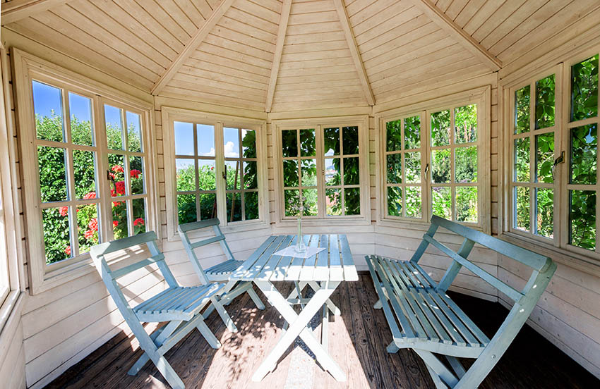 Gazebo with picture windows and rustic furniture