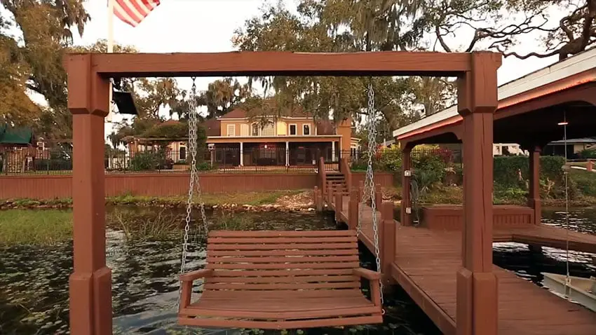 Wooden swinging bench on lake dock