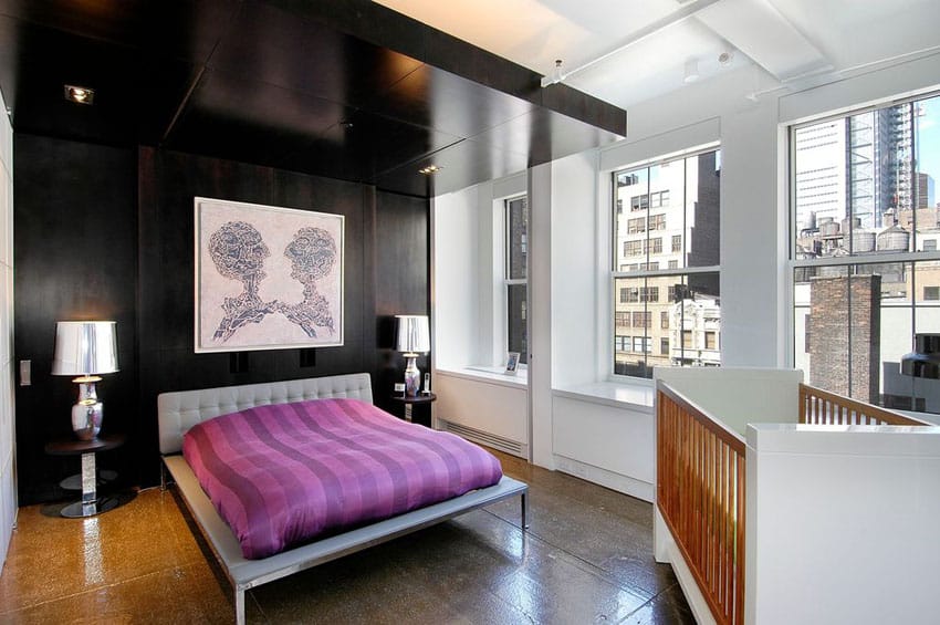Apartment bedroom with city views, silver tufted bed frame and black wall behind bed