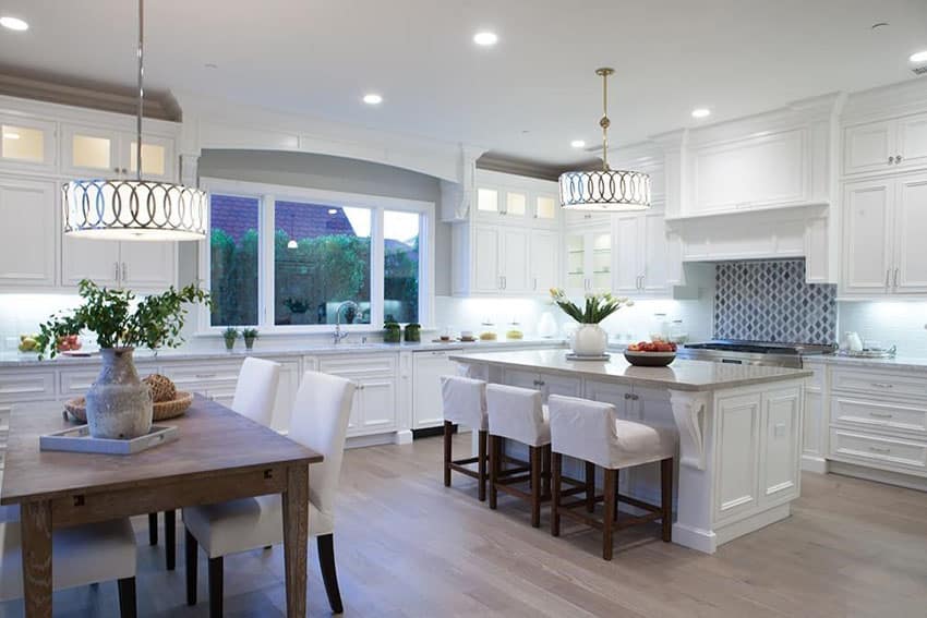 Beautiful transitional kitchen with white cabinets, gray granite counter, dining island and wood flooring