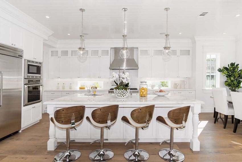 Beautiful kitchen with quartz counter island white cabinets and adjustable height swivel bar stools