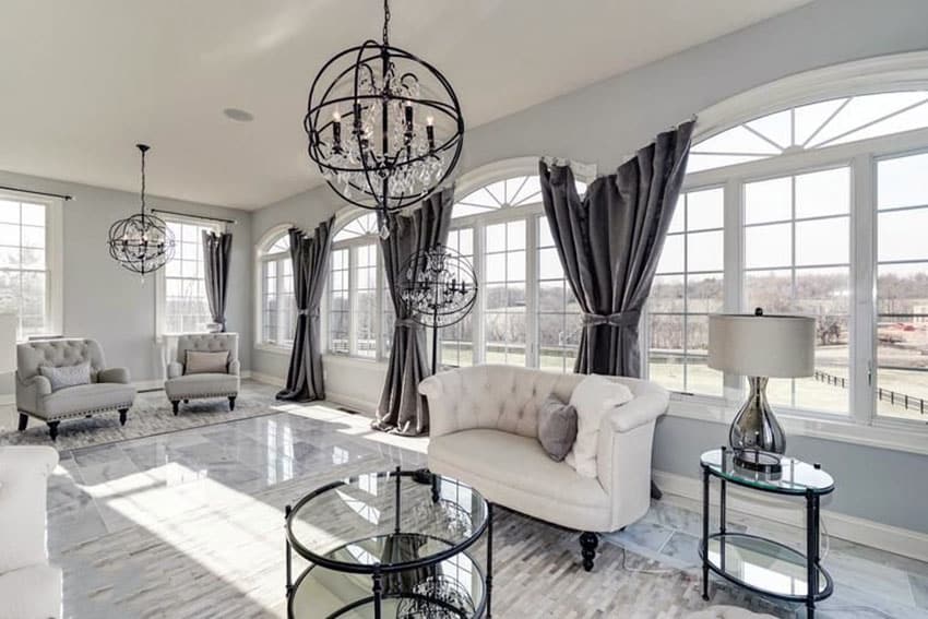 Beautiful living room with tile floors dark curtains and round modern chandelier lighting