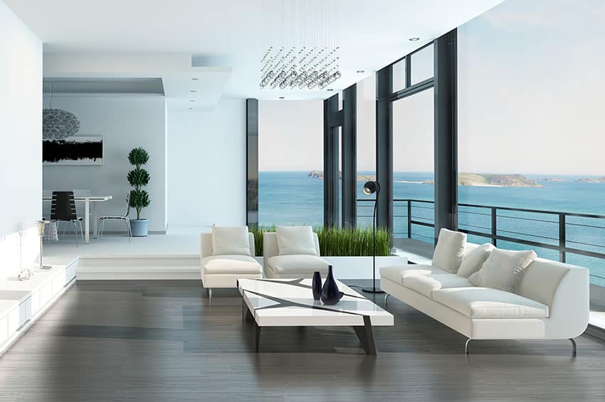 Room with white couches and seats and a view of the ocean