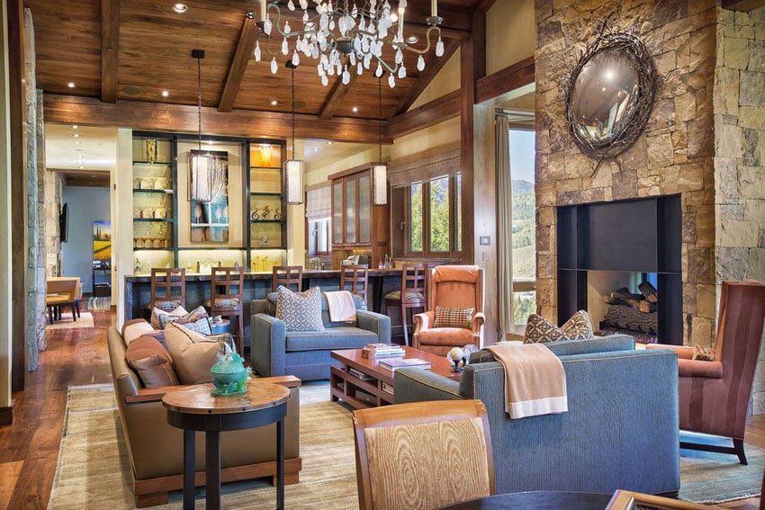 Rustic lroom with crystal chandelier, blue chairs and leather sofa