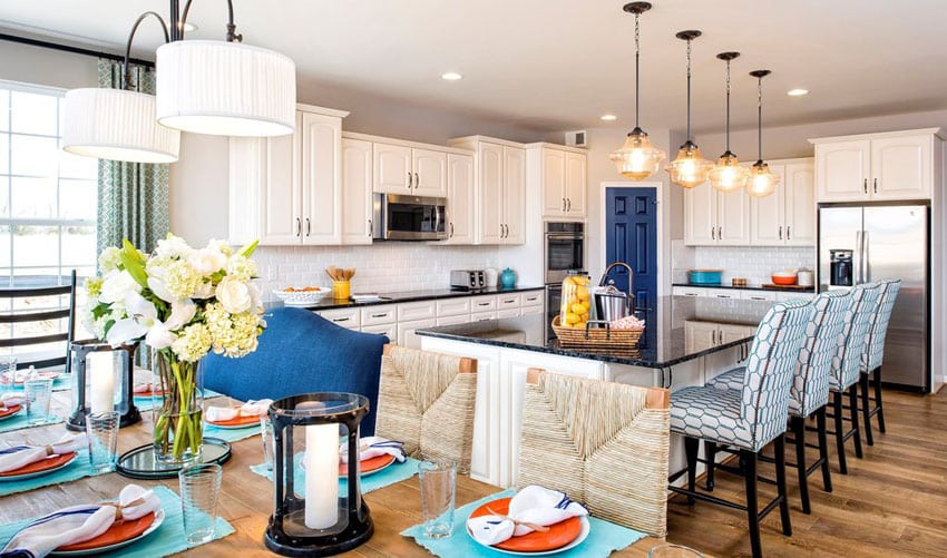 Beautifully decorated traditional kitchen with white cabinets, blue pearl silver granite counters and open dining area