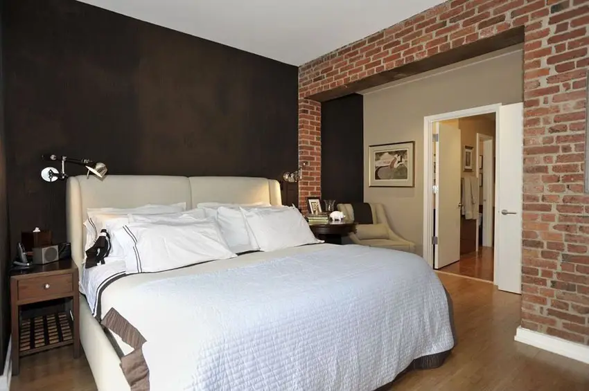 Bedroom with black painted walls and brick wall