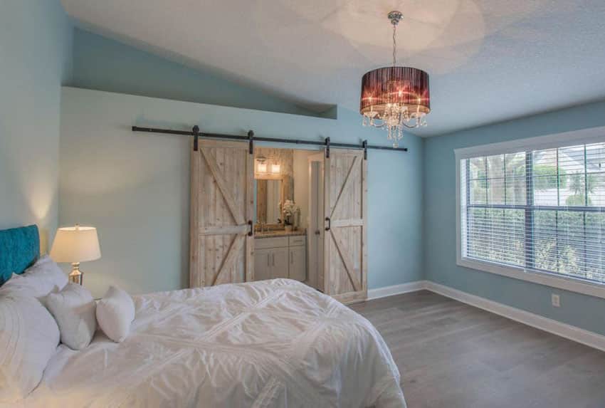 Bedroom with unfinished knotty alder sliding barn doors