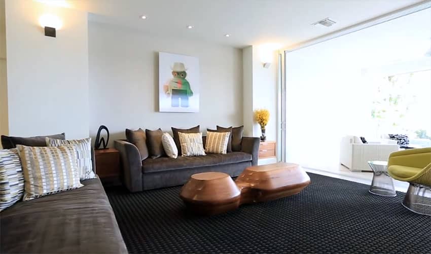 Casually decorated living room with dark color sofas and custom carved coffee table