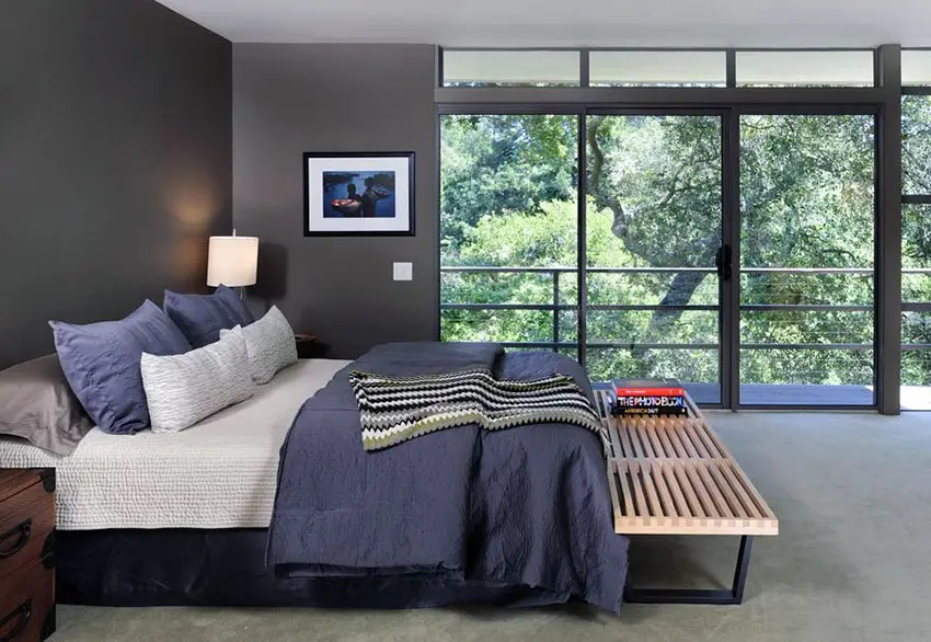 Contemporary bedroom with dark walls and wrap around outside views