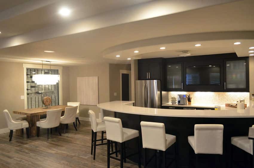 Contemporary kitchen with arctic white quartz counter and curved dining peninsula with white bar stools