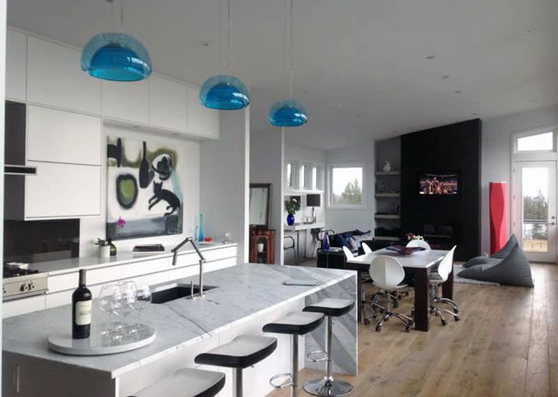Contemporary kitchen with marble island and adjustable swivel barstools and blue glass pendant lights
