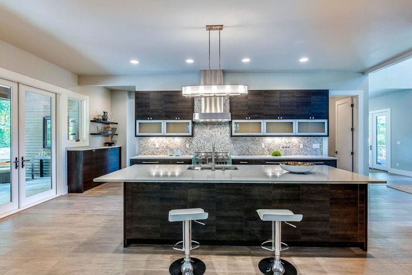 Contemporary kitchen with meridian gray quartz counter island with chrome bar stools and brushed beige marble tile floors