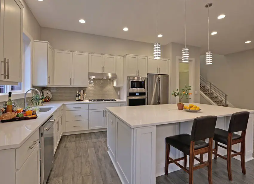 Contemporary kitchen with white cabinetry, wood flooring and aluminum mini pendant lights