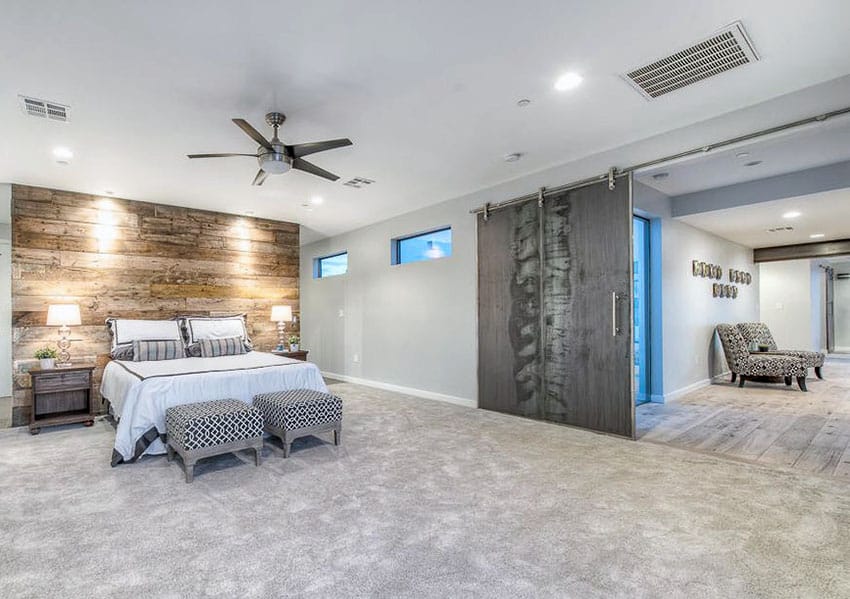 Contemporary master bedroom with distressed wood sliding barn door