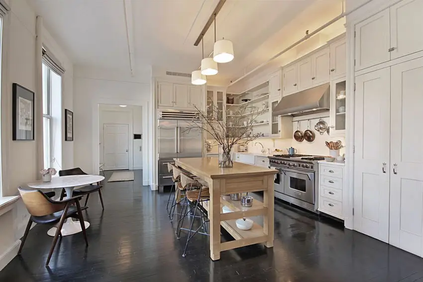 Contemporary kitchen with white cabinets and portable wood island