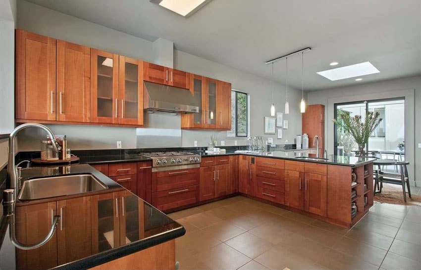 Craftsman kitchen with absolute black polished granite tops, brown shaker cabinets and large peninsula