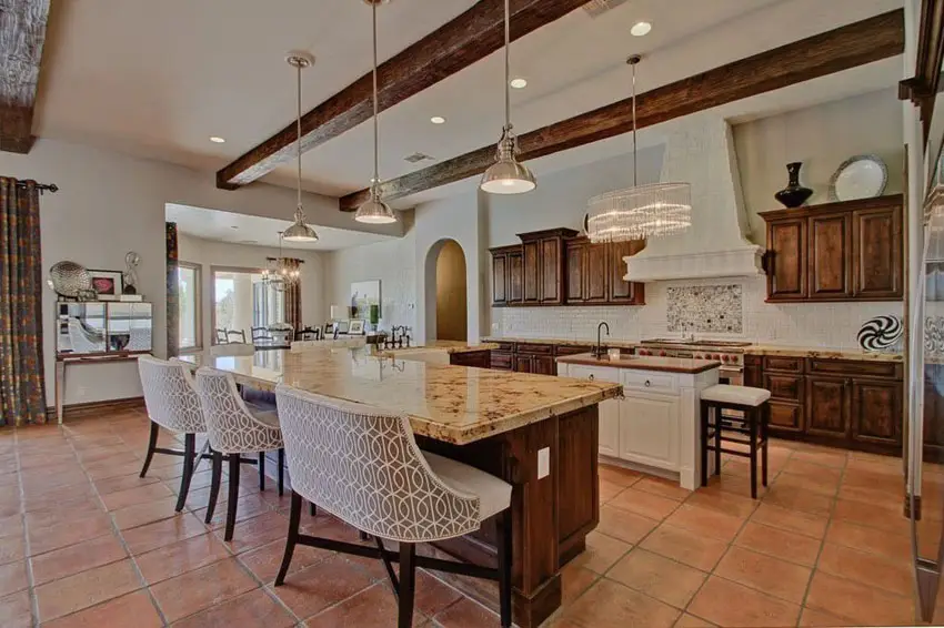 Craftsman kitchen with l shape island with seating and terra cotta flooring