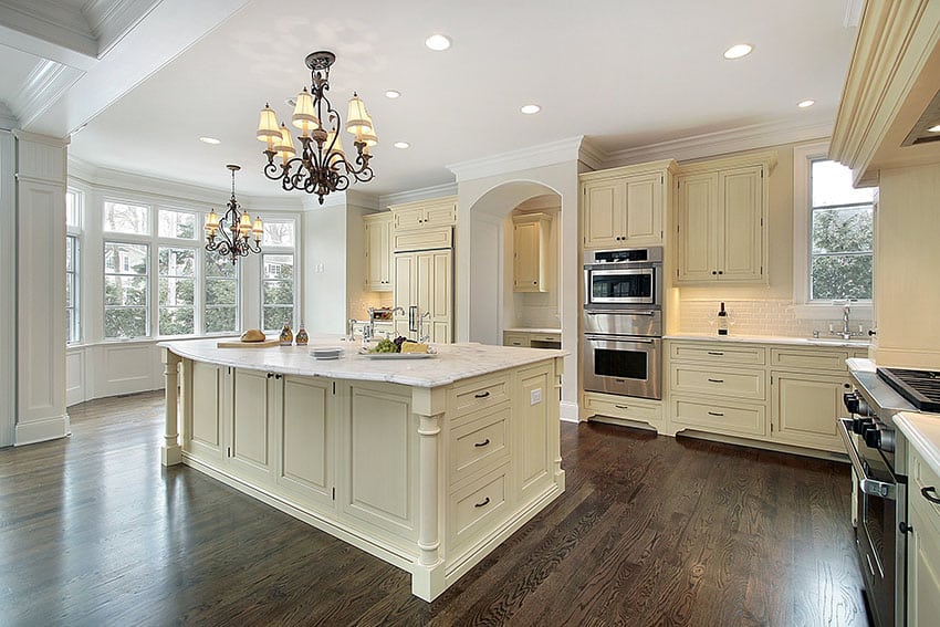 Cream color cabinet kitchen with marble counter, large island and wood floors