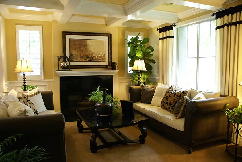 Decorated formal yellow living room with coffered box ceiling