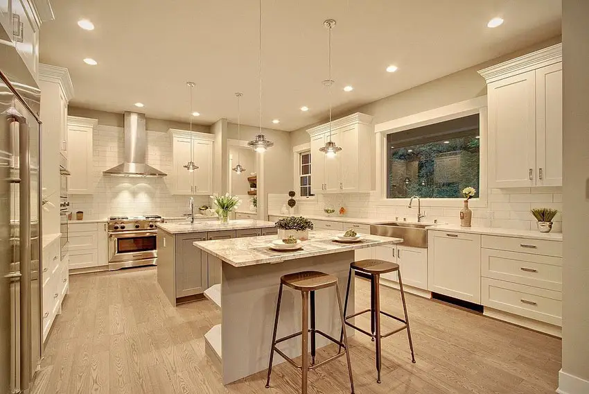 Double island transitional kitchen with gold marble countertops 