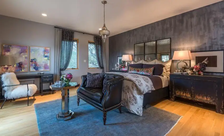Eclectic bedroom with dark accent wall and mirrored headboard