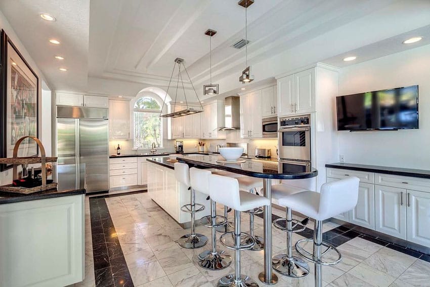 Eclectic kitchen with white cabinets and breakfast bar island with black granite counters
