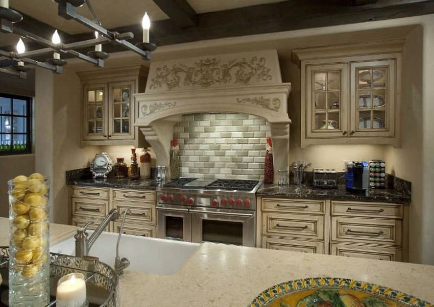 Elegant kitchen with cream cabinets with raised panel design and decorative oven hood
