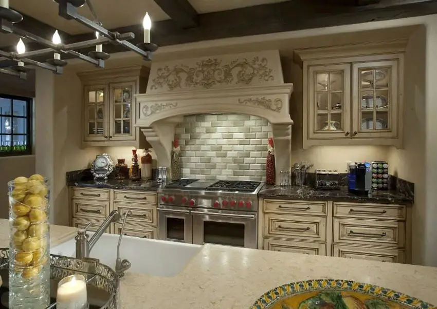 Kitchen with vine carving inlay on range hood, rusticated counter drawers and exposed beam ceiling