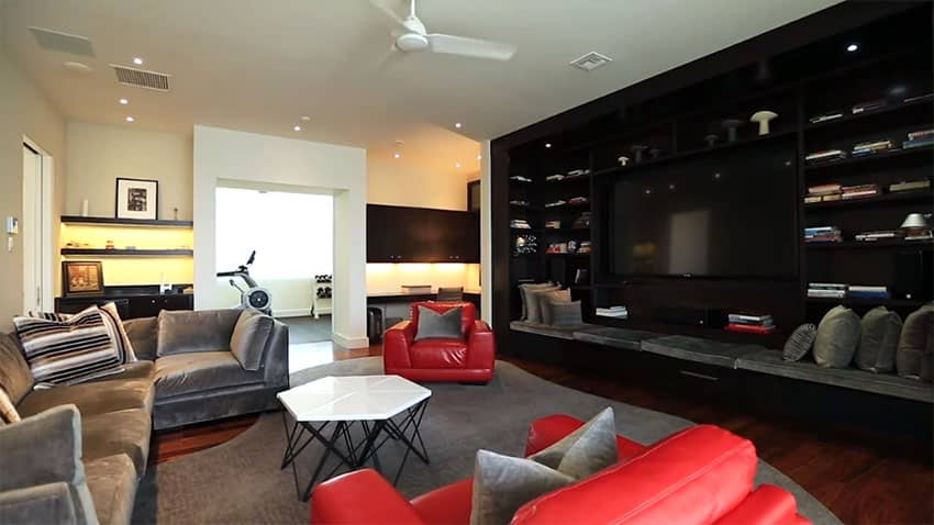 Family room with large black modern entertainment center with bench seating
