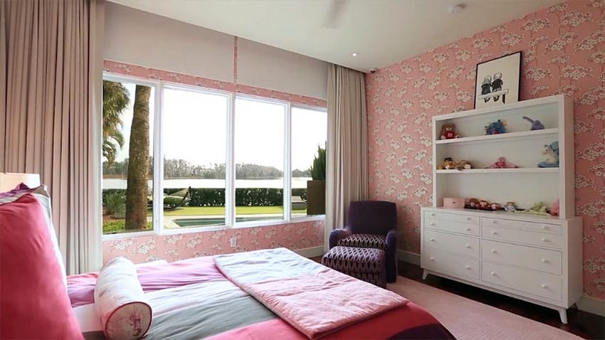 Girls pink and white bedroom with wallpaper and purple chair