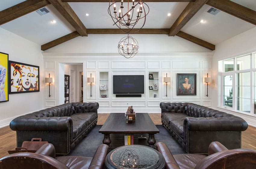Leather sectionals facing each other, exposed beams white paneled walls and artwork